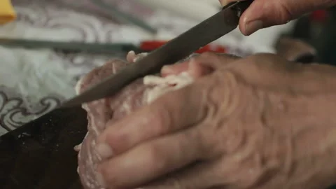Unrecognizable man cuts meat used knife, act inside the house on countryside Stock Footage 99486709