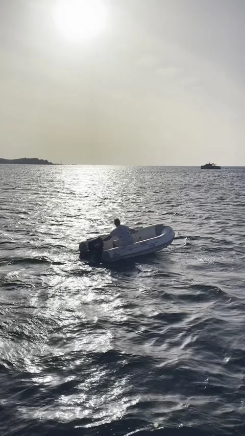 Unrecognizable Man on Dinghy Boat at Sunset in Greece Stock Footage 336964979