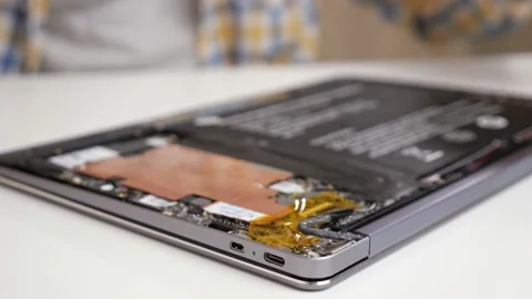 Unrecognizable man disassembles a laptop and looks through the parts with a Stock Footage 150478663