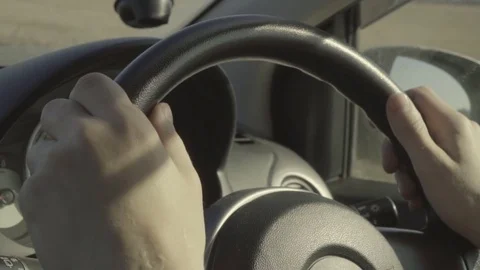 Unrecognizable man driving a car, close up hands on steering wheel. Sunny day Stock Footage 84887573