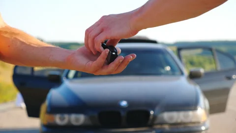 Unrecognizable man getting car key from seller. Male hands giving keys of car Video stock 135403864