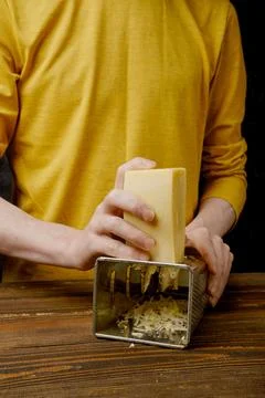 Unrecognizable man grating cheese in the kitchen Foto stock