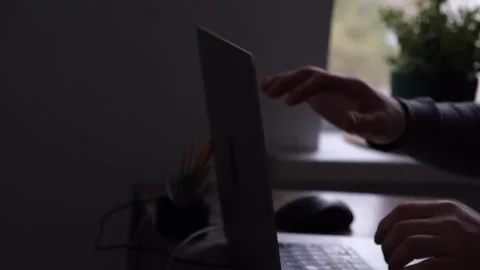 An unrecognizable man in gray closes his laptop after work. The concept of a job Stock Footage 274639418