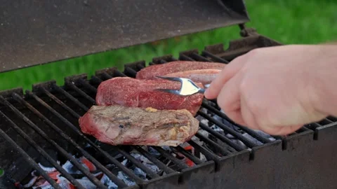 Unrecognizable man grilling steak outdoors Stock Footage 250444315