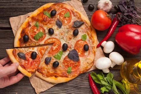 Unrecognizable man hand taking sliced piece of italian pizza mar Stock Photos