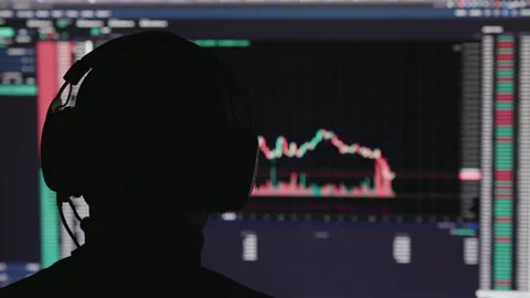 Unrecognizable man head in headphones in front of stock market trading chart Stock Footage 194812932