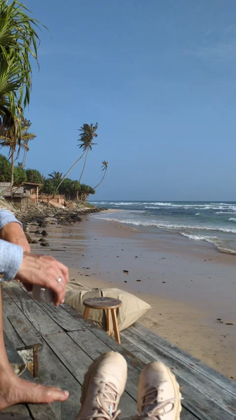 Unrecognizable man holding coffee cup sitting by tropical Stockbeeldmateriaal 322012479