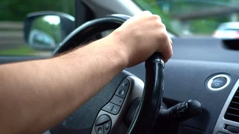 Unrecognizable man holding his hands on steering wheel and driving car Stock Footage 113616665