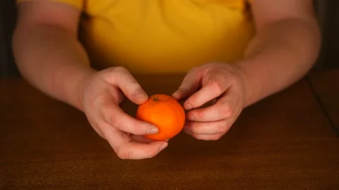 Unrecognizable man holding orange in his hands Stock Footage 125834331