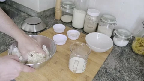 Unrecognizable man kneading bread dough and adding milk Stock Footage 131418837