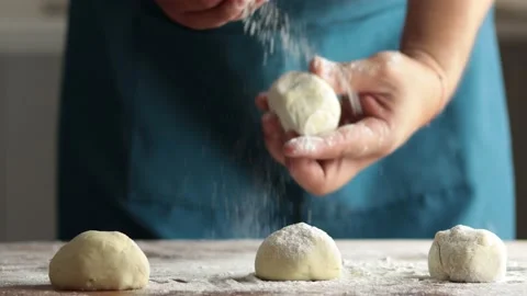 Unrecognizable man kneading dough by hand in the kitchen. Spreading flour on Stock Footage 229490288