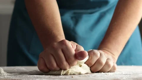 Unrecognizable man kneading by hand in home kitchen, on wooden table Stock Footage 229490352
