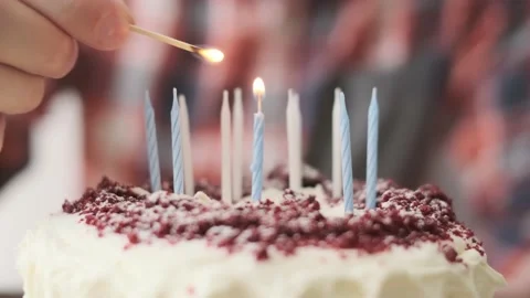Unrecognizable man lights candles on a birthday cake. Stock Footage 162805662