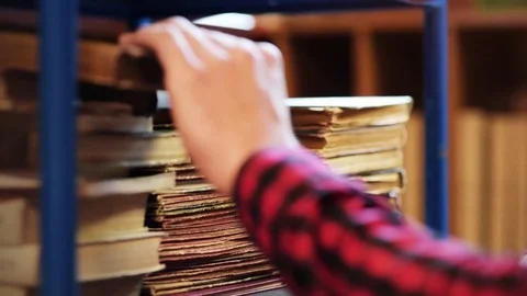 Unrecognizable man looking for book Video stock 77794711