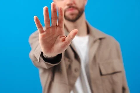 Unrecognizable Man making stop gesture with hand against blue background Stock Photos