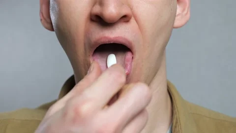 Unrecognizable man man puts pill on his tongue and swallows Stock Footage 171150314