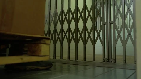 An unrecognizable man opens the doors of a freight elevator in the self-storage Video stock 274885197