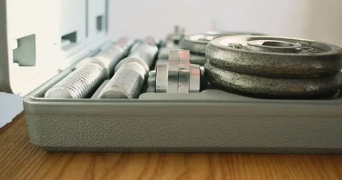 Unrecognizable man opens a plastic case with a set of dumbbells. Takes out the 動画素材 220367704