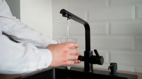 Unrecognizable man pouring drinking water into transparent clean glass Stock Footage 153284672