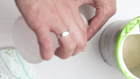 Unrecognizable man preparing baby bottle of powdered milk. Zenith. Stock Footage 219735155