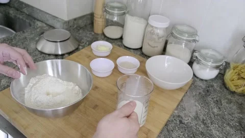 Unrecognizable man preparing the ingredients to make bread dough: flour, milk Stock Footage 131418762
