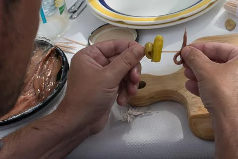Unrecognizable man preparing spanish tapas with chili pepper, olive and ancho Stock Photos