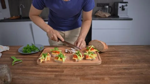 Unrecognizable man preparing a tasty snack. Bruschetta with cheese and Stock-Footage 317552470