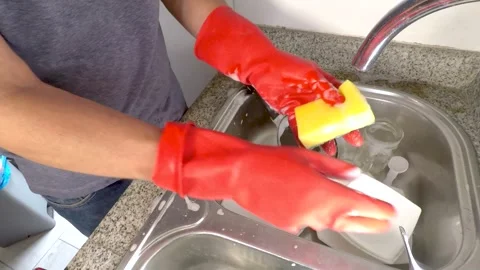 Unrecognizable man in red gloves washing dishes in the kitchen sink Stock Footage 278954560
