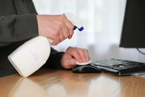 Unrecognizable man sanitizing workplace Stock Photos
