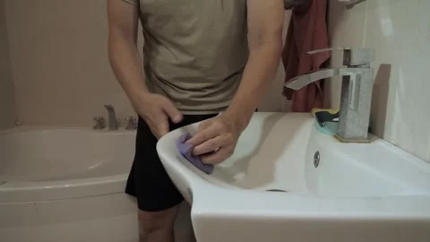 Unrecognizable man scrubbing white ceramic sink Stock Footage 340016775