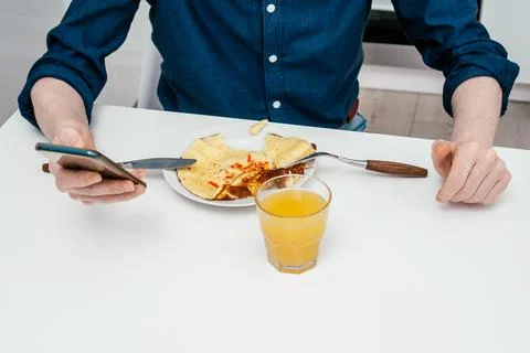 Unrecognizable man sitting in front of round plate with vegetable omelette and Stock Photos