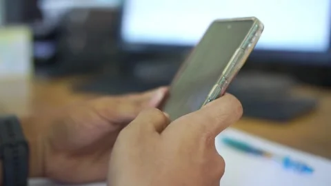 Unrecognizable man sitting at work place desk with smart phone in hands Stock Footage 322116118