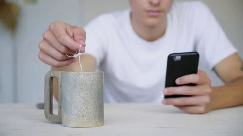 Unrecognizable man steeps herbal tea in big mug Video stock 79829746