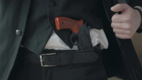 Unrecognizable man in a suit pushes the jacket back and shows the gun hidden Stock Footage 108418791