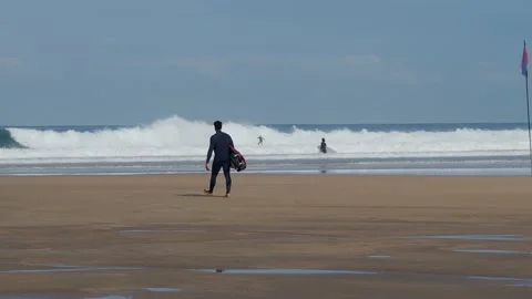 Unrecognizable man with surfboard in hand on a beach. Surfer Stock Footage 166005544