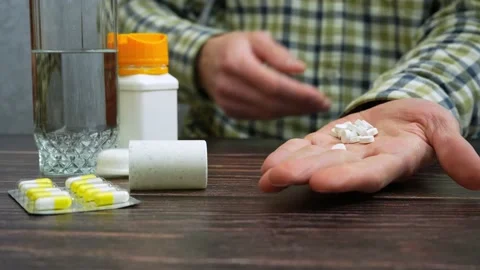 Unrecognizable man takes many white pills Видео 235932145