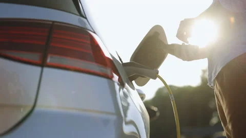 Unrecognizable man unplugging electric car from charging station. Male 스톡 동영상 200843423