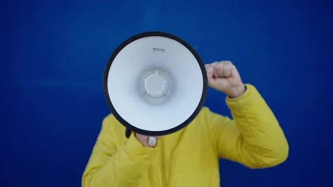 Unrecognizable man uses a megaphone to demonstrate his indignation against wars. Stock Footage 274809847