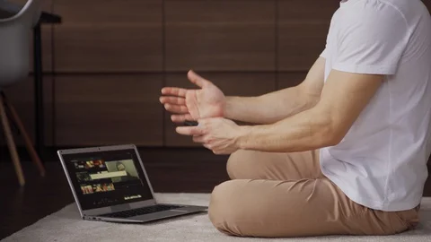 Unrecognizable man using hand sanitizer while working on laptop Video stock 128762073