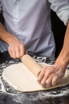 Unrecognizable man using rolling pin on dough Stock Photos