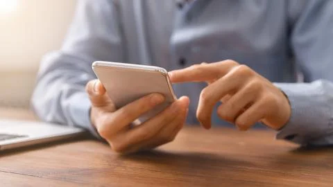 Unrecognizable man using smartphone checking his money balance 写真素材
