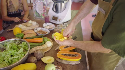 Unrecognizable man using spoon to peel the mango already cut in dices Stock Footage 219018691