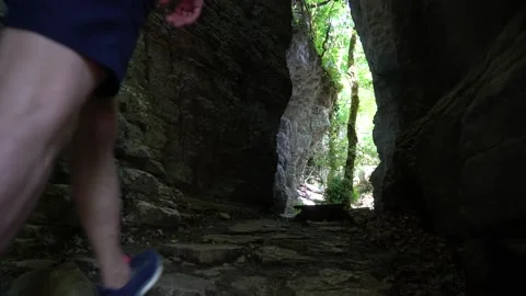 Unrecognizable man walks through a dark cave Stock Footage 132134309
