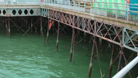 Unrecognizable man welding underneath a vintage old harbor bridge by the sea. Stock Footage 168773413