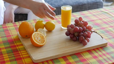 Unrecognizable Man with white pant taking a glass of orange juice on Table Stock Footage 112037863