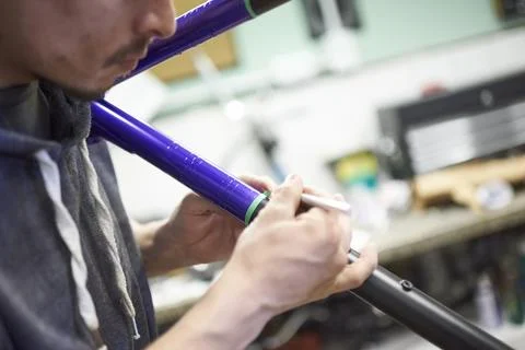 Unrecognizable man working on a custom bicycle frame painting design. Stock Photos