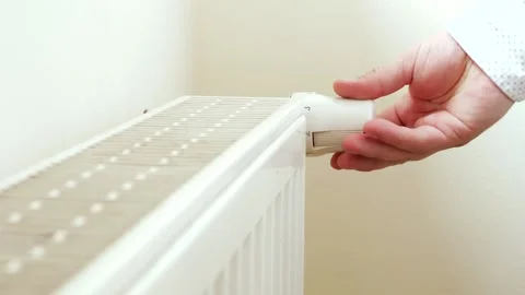 Unrecognizable man's hand setting temperature on central heating system Stock Footage 136649724