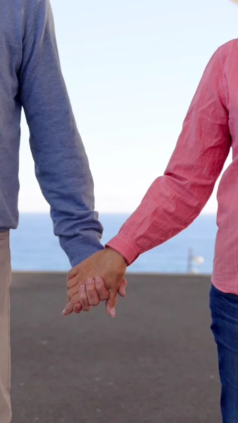 Unrecognizable mature couple walking down the street and holding hands Video stock 259592295