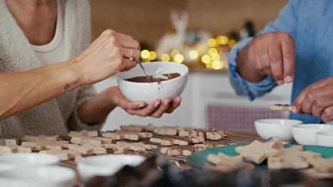 Unrecognizable multi ethnicity couple decorating sweet cookies at home during th Stock Footage 218775227