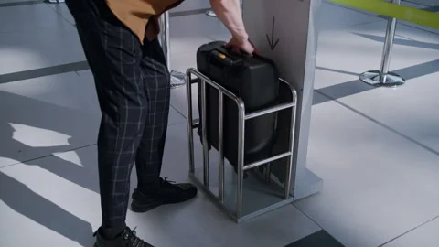 Unrecognizable Passenger checking carry on luggage size at airport Stock Footage 334566991